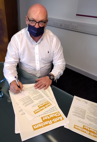 Photo of Sean Leahy, Executive Director of People and Culture at EPUT, signing UNISON’s anti-racism charter.
