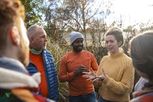 Group of people in the countryside. Standing in a circle, talking.